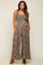 woman wearing a floral maternity jumpsuit with wide legs and pockets, featuring a square neckline and ruffled straps