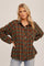 blonde woman wearing an oversized green and brown plaid flannel shirt with light wash jeans