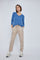 Woman wearing a blue v-neck long sleeve shirt and beige drawstring joggers with white sneakers