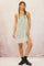 woman wearing a white and black checked slip dress with spaghetti straps and a textured hem, styled with chunky shoes