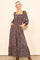 woman wearing a navy blue floral maxi dress with long sleeves and pockets, standing with hands in pockets