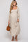 woman wearing a floral maternity maxi dress with a square neckline and puff sleeves, holding a brown handbag, baby bump visible
