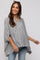 woman wearing a striped maternity top with a button-down front and relaxed fit, smiling while standing against a light background