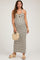 woman wearing a black and white striped maternity maxi dress with a halter neckline and holding a woven bag