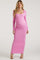 woman wearing a pink long sleeve maternity maxi dress and showing her baby bump