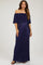 woman wearing a navy off-shoulder maternity maxi dress with a flowing top and vertical stripes, showing her baby bump