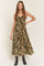 woman wearing a brown floral maxi dress with a sweetheart neckline and tie detail, styled with black cowboy boots