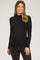 woman wearing a black long sleeve maternity top and smiling with her baby bump visible