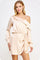 woman wearing a blush off-the-shoulder satin dress with long sleeves and a side wrap detail
