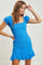 woman wearing a bright blue short sleeve fitted dress with ruffled sleeves and a flared hem
