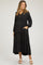 woman wearing a black maternity maxi dress with tiered design and v-neckline, showing her baby bump