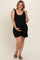 woman wearing a black sleeveless maternity romper with tie details, holding her baby bump
