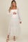 woman wearing a white maternity maxi dress with puffed sleeves and tiered tulle, holding her baby bump