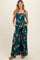 woman wearing a teal floral maternity jumpsuit with a smocked bodice and wide legs, featuring pockets