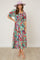 woman wearing a colorful floral maxi dress with puff sleeves and a square neckline, paired with a light purple hat