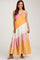 woman wearing a colorful tiered maternity dress with pink, white, orange, and yellow sections and spaghetti straps