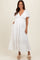 woman wearing a white maternity maxi dress with flutter sleeves and a baby bump visible