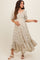 woman wearing a floral print maternity maxi dress with puff sleeves and a tiered hem, gently holding her baby bump