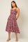 woman wearing a floral print midi dress with spaghetti straps and a flared skirt in vibrant pink and purple tones