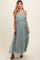 woman wearing a flowing mint green maternity maxi dress with spaghetti straps and a visible baby bump