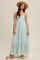woman wearing a light mint green tiered maxi dress with spaghetti straps and a straw hat
