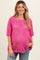 woman wearing a bright pink open knit maternity top with short sleeves and a visible baby bump