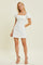 woman wearing a white mini dress with puff sleeves and a square neckline