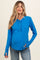 woman wearing a bright blue long sleeve maternity top with buttons and a visible baby bump