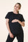 woman wearing a black short sleeve maternity top and holding her baby bump