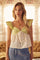 woman wearing a light green and floral print sleeveless top with ruffle sleeves and a flared hem