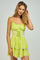 woman wearing a lime green tiered mini dress with spaghetti straps and lace trim details