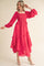 woman wearing a bright pink tiered midi dress with puffed sleeves and ruffle details