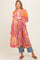 woman wearing a colorful floral maternity kimono with 3/4 sleeves and a visible baby bump, styled over jeans