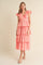 woman wearing a pink tiered maxi dress with ruffle details and short sleeves