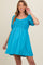 woman wearing a bright blue maternity dress with a smocked bodice and short puff sleeves, showing her baby bump