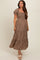 woman wearing a brown floral maternity maxi dress with puff sleeves and a smocked bodice