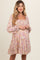 woman wearing a floral print maternity dress with a square neckline and tiered skirt, showing her baby bump
