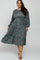 plus size woman wearing a long sleeve teal floral pleated midi dress with brown heels