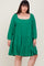 woman wearing a green tiered swing dress with long sleeves and a square neckline, styled for plus size