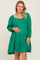 woman wearing a green tiered maternity dress and holding her baby bump