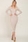 Woman wearing a long sleeve beige ribbed midi dress with a v-neckline and tan pointed toe heels
