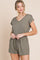 woman wearing olive green v-neck short sleeve romper with drawstring waist and pockets