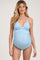 woman wearing a light blue maternity swimsuit with a plunging neckline and ruched detailing, showing her baby bump