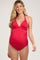 woman wearing a red maternity one-piece swimsuit with a deep neckline, showcasing a visible baby bump