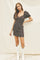 woman wearing a fitted black floral mini dress with puff sleeves and white cowboy boots