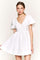 woman wearing a white puff sleeve mini dress with a v-neck and a flared skirt