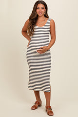 woman wearing a black and white striped maternity dress with a fitted silhouette and side slits, holding her baby bump