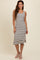 woman wearing a striped midi tank dress in black and cream with a fitted silhouette and a flared hem