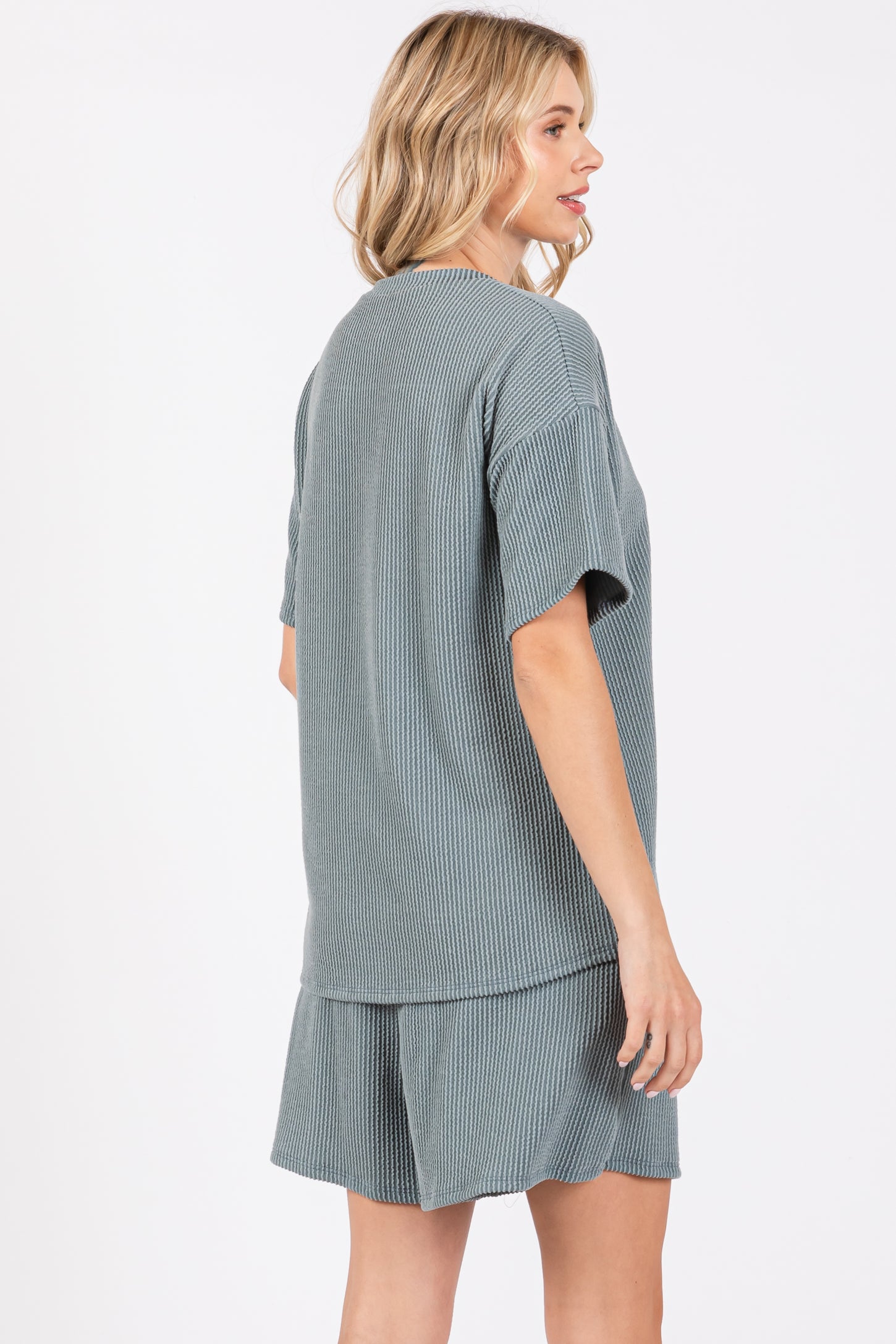 woman wearing a short sleeve ribbed lounge set in soft teal, featuring a relaxed fit and a matching short