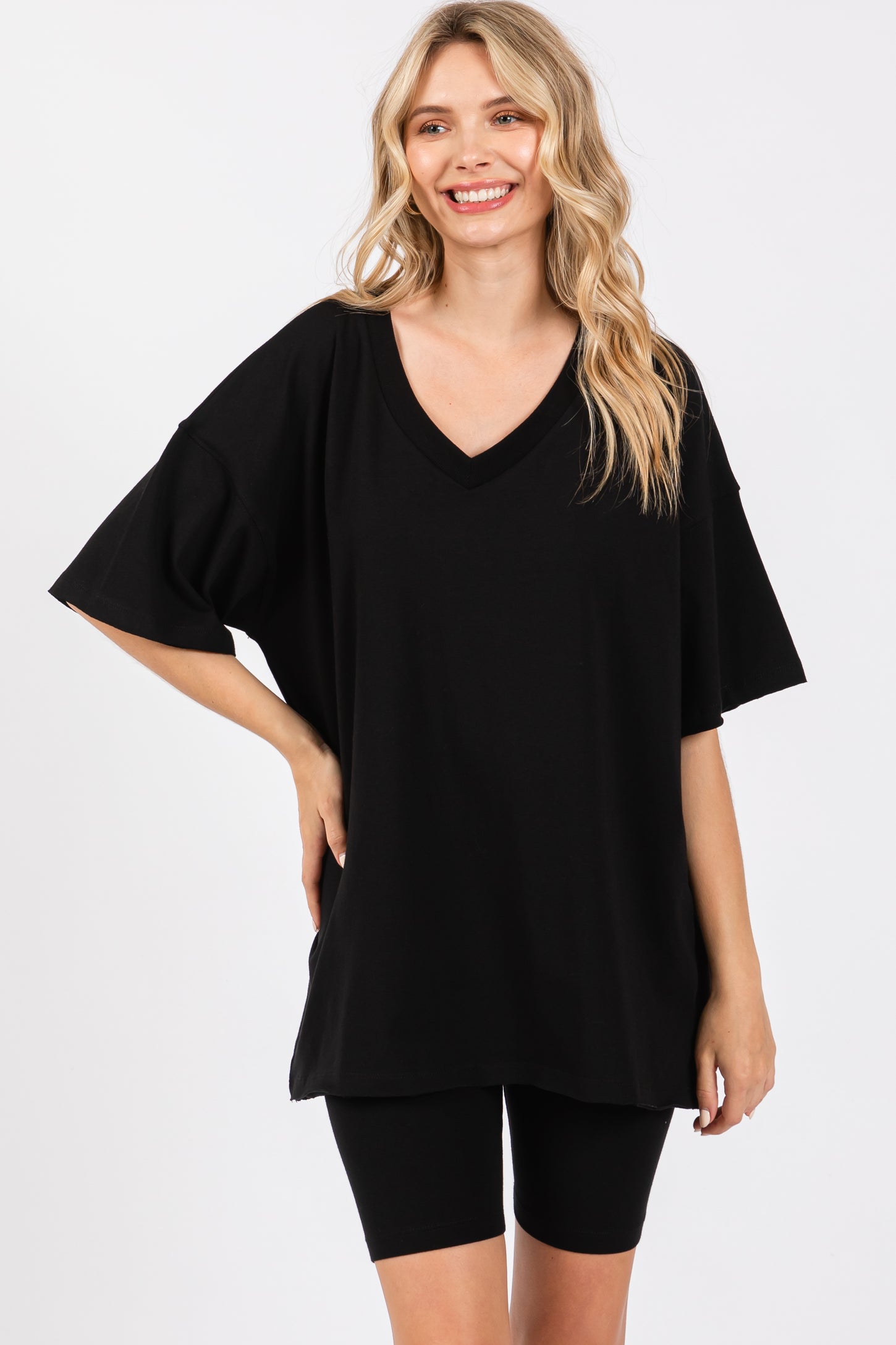 woman wearing a loose black oversized v-neck t-shirt with short sleeves, paired with black bike shorts